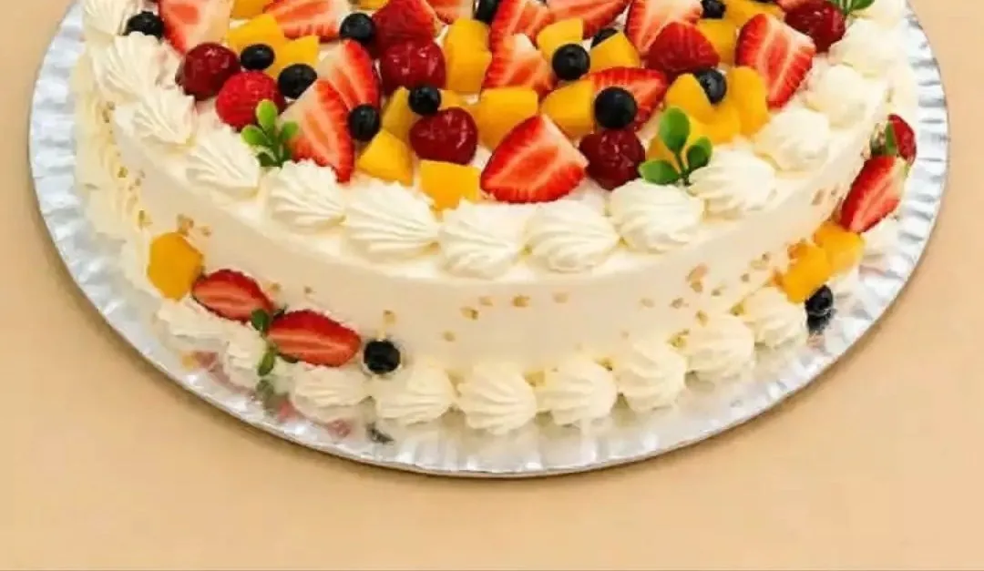 Detalhe de bolo com cobertura de chantilly e frutas frescas da Doceria Alteza